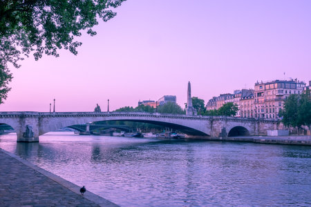 France. Early morning in summer Paris. Seine River embankment and bridges and barges by the shoreの写真素材