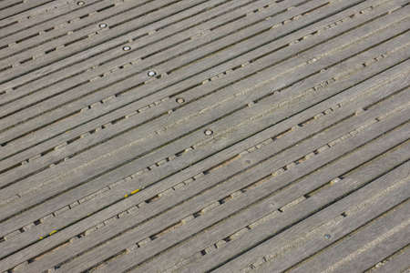 Background. Decking made of old bolted wooden battens. Remains of old cement between the slats
