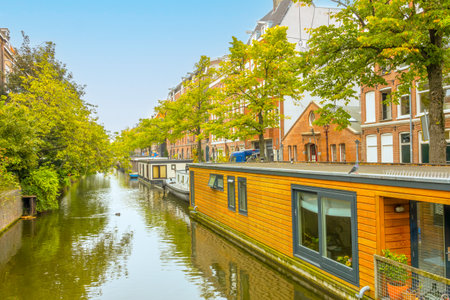 Netherlands. Summer day in Amsterdam. Houseboats along the bank of a narrow canalの写真素材