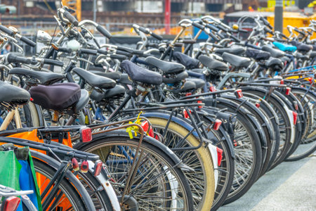Netherlands. Daytime Amsterdam. Many bicycles in a parking lot on a defocused street backgroundの写真素材