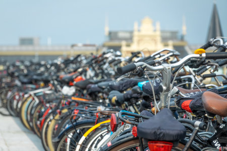 Netherlands. Many bicycles in a bicycle parking lot against the backdrop of an austere facade near Amsterdam Central Stationの写真素材