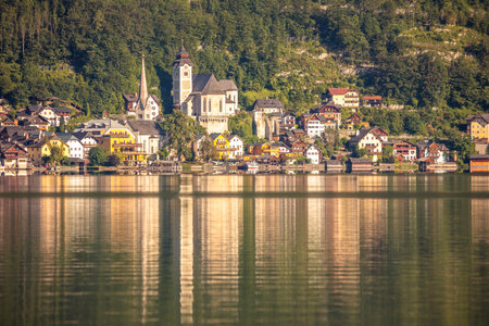 Summer Austria. The sun illuminates the small town of Hallstatt on the lake. A mirror of calm waterの写真素材