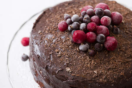 Homemade fresh chocolate birthday cake with organic frozen berries and chips on the top. Crystal...