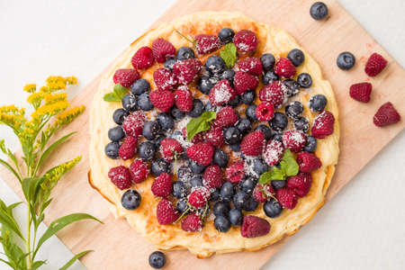Fresh berries on the tart cake from above. Delicious homemade pie with organic raspberries and...