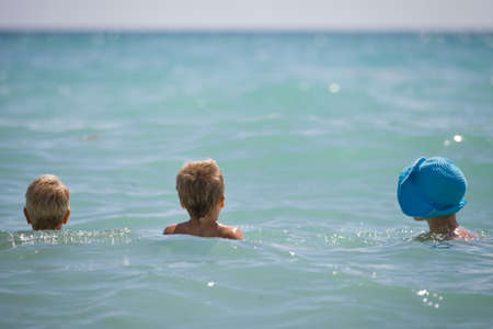 Mother with two children swimming on the ocean on a sunny day. Family on sea vacations.の写真素材