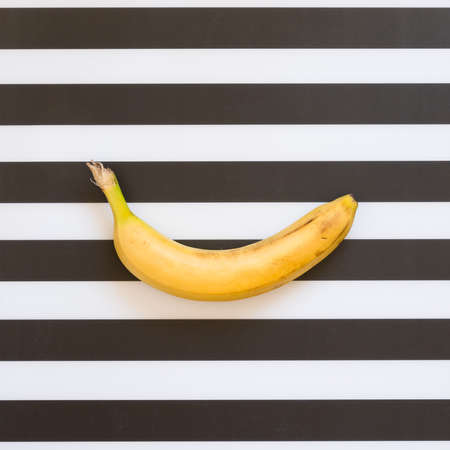 Organic banana on black and white stripes background. top view.の写真素材