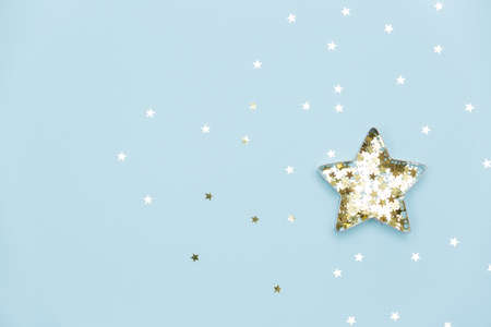 Christmas star made with mold for the cookies and gold sparkling stars on blue background. Flat lay. Holidays and Christmas conceptの写真素材