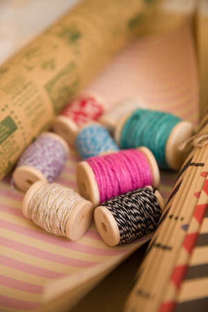 spools of colorful thread on holidays wrapping paper. Gift packing. Material for present package....