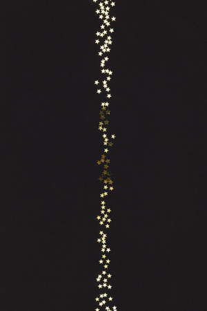 Line of golden stars on black background.