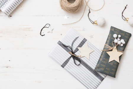 Top view on nice Christmas gifts packed in black and striped paper and decorated with stars on wooden background. Presents and decor elements. Holidays and winter concept.の写真素材