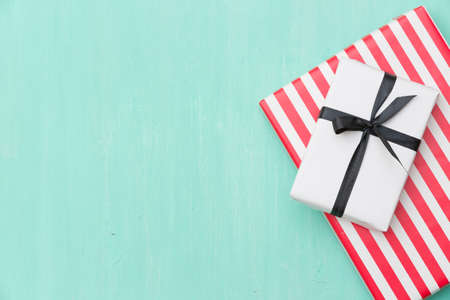 Top view on Christmas gifts wrapped in striped gift paper decorated with ribbon on turquoise wooden background with sparkling stars. New Year, holidays and celebration conceptの写真素材