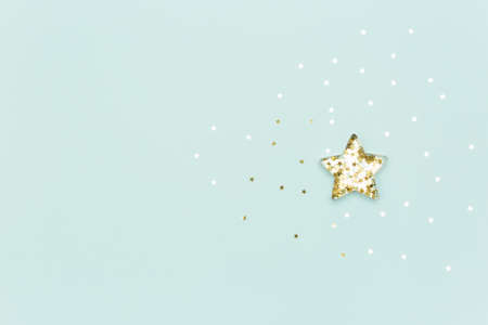 Christmas star made with mold for the cookies and gold sparkling stars on blue background. Flat lay. Holidays and Christmas conceptの写真素材