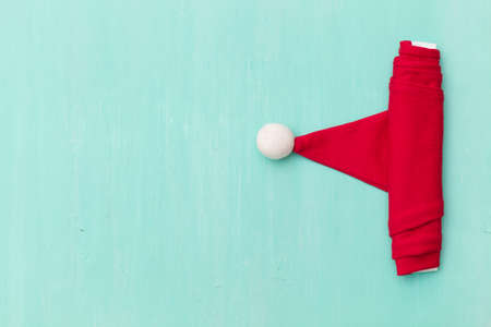 Top view on Santa's hat on retro wooden turquoise background. Christmas, winter and holidays season concept.の写真素材