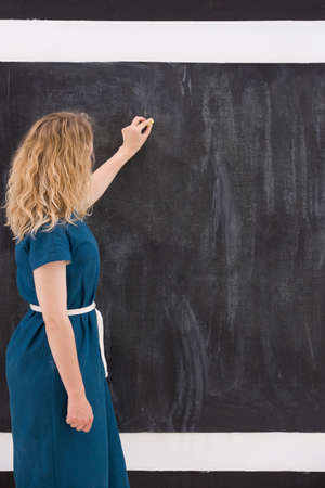 Young girl drawing on a black background. Business woman writting on the board. Teacher hand drawing on chalkboard. Education and idea concept.の写真素材