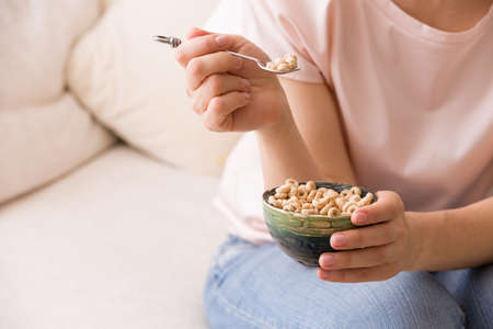 Closeup of woman's hands holding bowl with organic whole wheat cereal. Healthy Breakfast or snack. Healthy food and eating.の写真素材