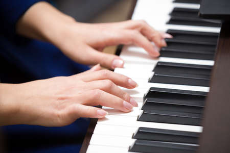Closeup of hands playing piano. Music and hobby concept