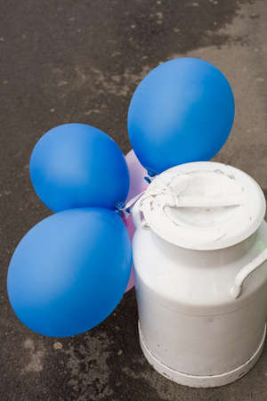 White retro can with blue baloons on the asphalt road.の写真素材
