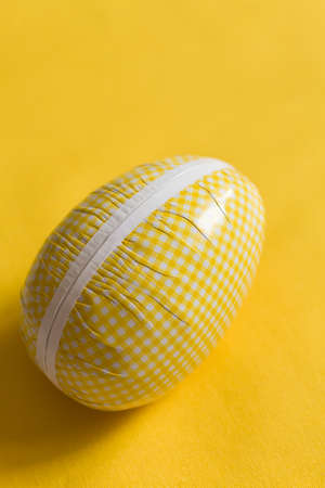 Easter egg box with candy and chocolate, scandinavian tradition. close up on yellow backgorund.  big Easter egg full of sweets and cookies. celebrating Easter. easter surprise.の写真素材