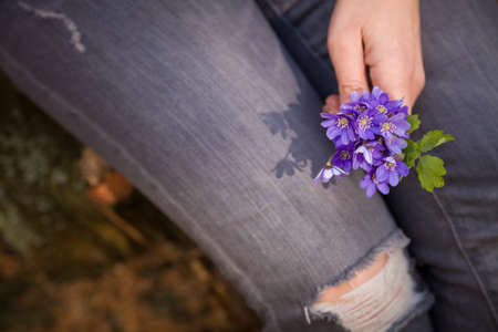 Woman holding beautiful snowdrop.  first spring flowers in a forest.  Wild flowers. spring concept.の写真素材