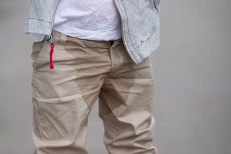 A young kid peeing on his pants on the street - Bed-wetting concept. Child pee on clothes.の写真素材