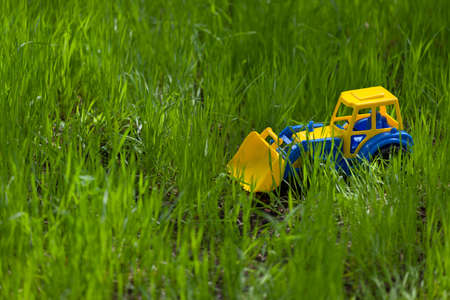 Toy colorful tractor in the grass. Child's toy in the garden. outdoors.の写真素材