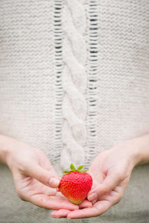 Closeup of woman's hands holding big strawberry.の写真素材
