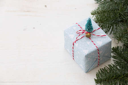 Packing Christmas gifts box on white wooden table. Top view with copy space