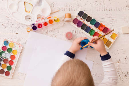 Top view on child's hands drawing. Colorful picture made by a toddler boy. Creative ideas and learning. Education concept.の写真素材