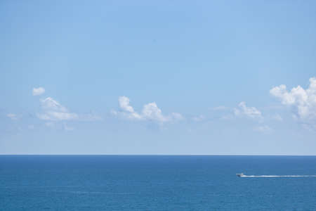 Beautiful view on Atlantic ocean. Small boat in the sea. Summer vacations destination. Traveling. Sky, sea and clouds,の写真素材
