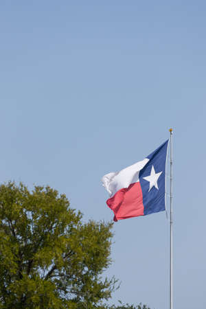 Texas flag waving against blue sky. State Flag of Texas on a Windy Dayの写真素材