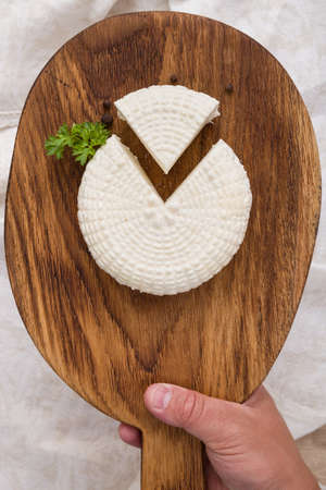 Top view on sliced round white homemade cheese  - traditional milk creamy dairy product on vintage...