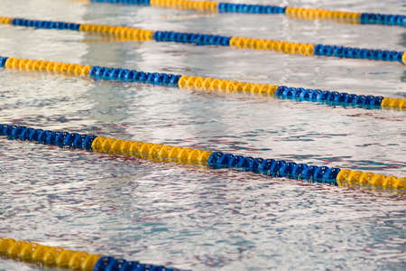 The view of an empty public swimming pool indoors. Lanes of a competition swimming pool. Sport...