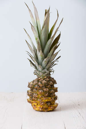 Closeup of cut pineapple on white wooden table and  on light blue background.の写真素材