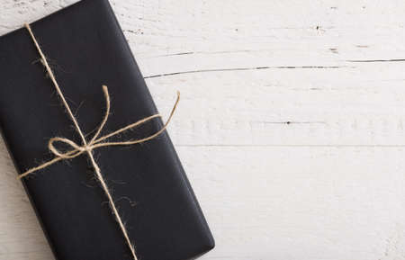 Top view on Christmas, birthday or any other celebration gift wrapped in  black paper and decorated...