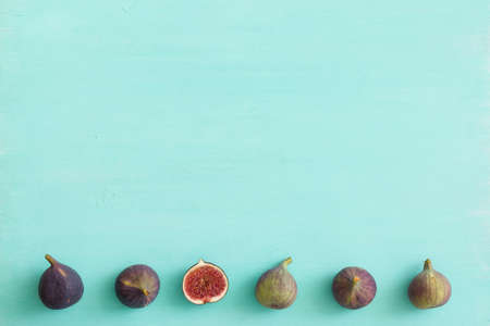 Top view on fresh figs on turquoise wooden table background. Healthy snack and food.の写真素材
