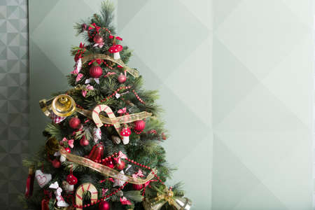 Nice Christmas tree decorated with red, gold and whiter decorations. Preparing for holiday season