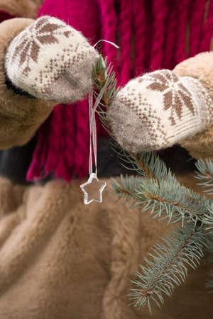 Closeup of young woman's hands near a Christmas tree on a cold winter day.の写真素材