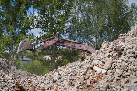 Heavy equipment being used to tear tearing down building construction. Many broken bricks and cement.の写真素材