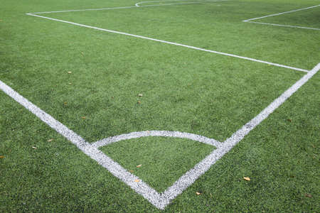 Closeup of Football and soccer field corner with white marks, green artificial grass texture in soccer stadium.の写真素材