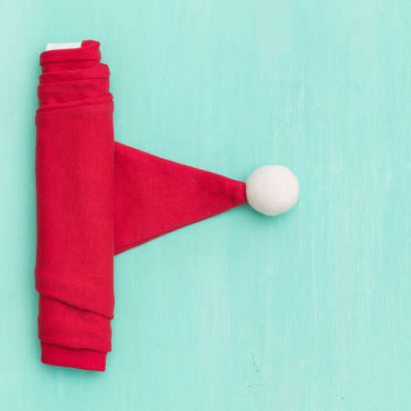 Closeup of Santa's hat on old wooden turquoise table or background. Christmas, New Year, winter and holidays season concept.の写真素材