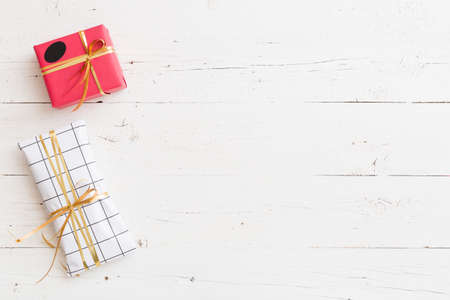 Top view on nice Christmas, birthday or any other celebration presents on white wooden background. Gifts. Holiday season.の写真素材