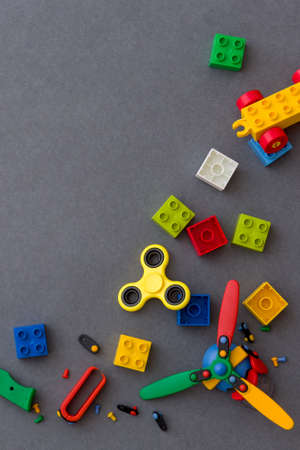 Closeup of colored plastic cubes and bright yellow spiner on gray background. Toys and other equipment for the early development of the child.の写真素材