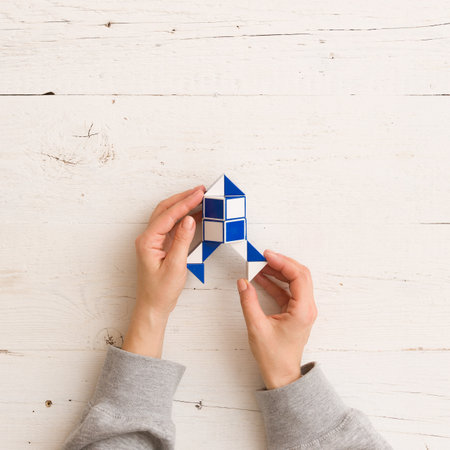 Moscow, Russia, February 16 2018: Rubik's snake puzzle in rocket shape in woman's hands, closeup,...