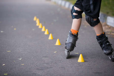Closeup of kid boy's roller skaters doing twists on asphaltの写真素材