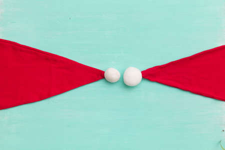 Top view on Santa's hats on retro wooden turquoise background. Christmas, winter and holidays season...