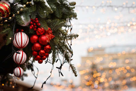 Multi-colored Christmas toys hang on an evergreen tree. Christmas decorations on the streets in the center of evening Moscow. Holiday concept. Selective focusの写真素材