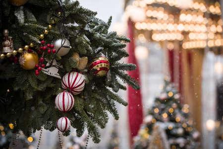 New Year's toys hang on an evergreen spruce hung with sparkling garlands. Christmas decorations on the streets in the center of Moscow. Holiday concept.の写真素材