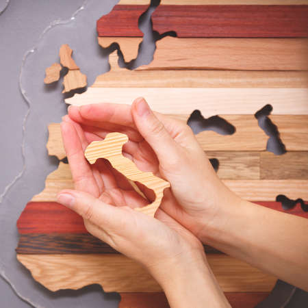 Closeup of the Italian peninsula in the hands of a girl. Tourism, life and work in Italy. Italian cultureの写真素材