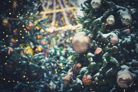 Big beautiful toys hang on a Christmas tree, hung with sparkling garlands and covered with snow. New Year decorations on the streets of Moscow. Winter New Year holidays. Selective focusの写真素材