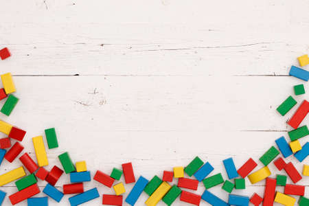 Directly above on colorful wooden cubes on a white wooden table background.